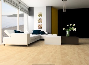 A modern living room featuring a white sofa, a glass coffee table, and a vase of flowers on a dark table, with large windows overlooking a serene view of the water.