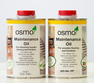 Two cans of Osmo Maintenance Oil for wooden flooring and furniture, labeled clearly for interior use with indications of clear satin finish.